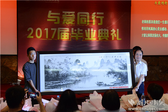 党委委员、组织部长李友虎接过了毕业生赠送母校的牌匾